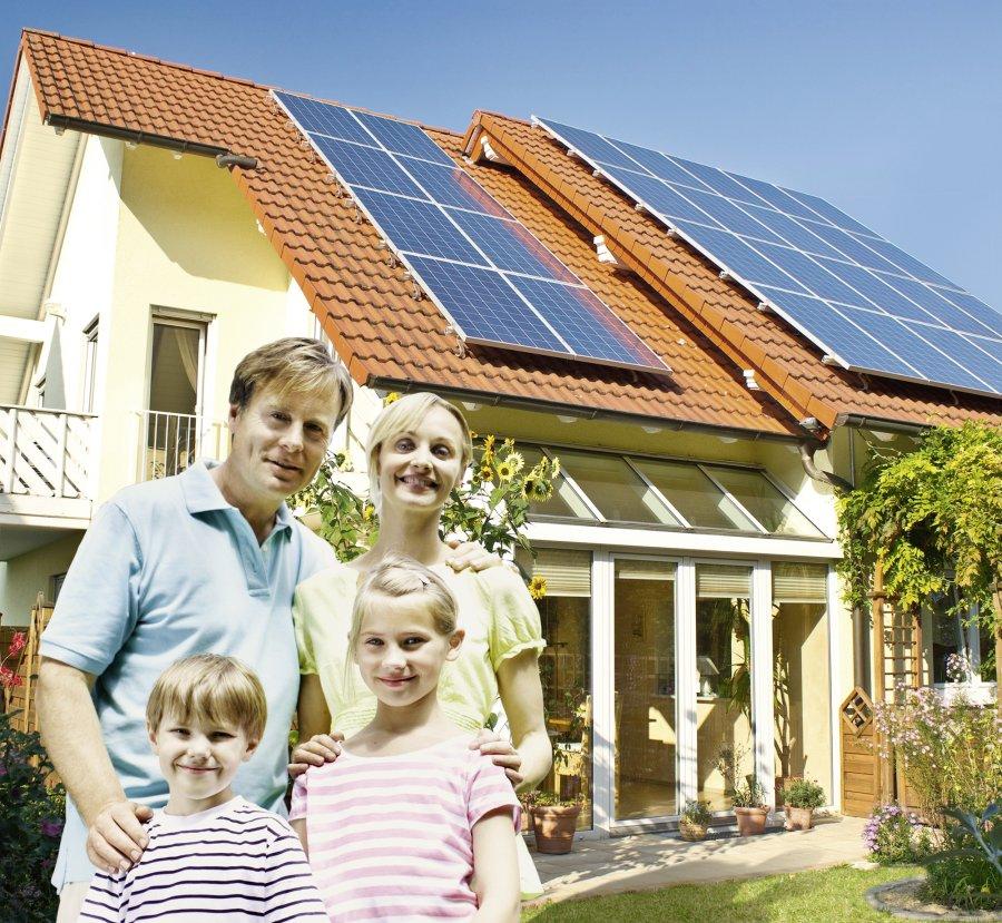 A family in front of their house with solar rooftop installation.