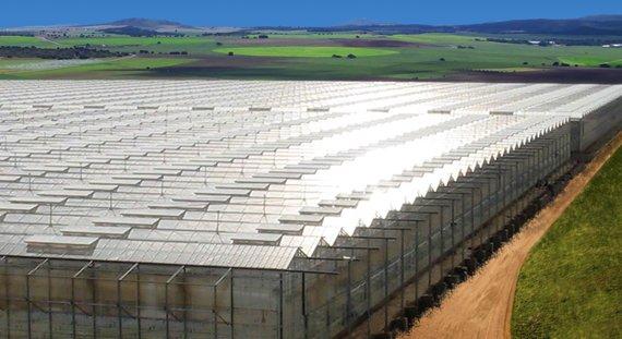 A solar greenhouse in a wide landscape.