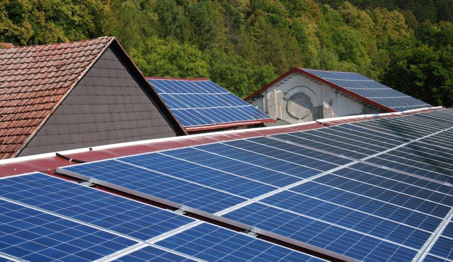 Rooftop solar panels on a house with mountains in background.