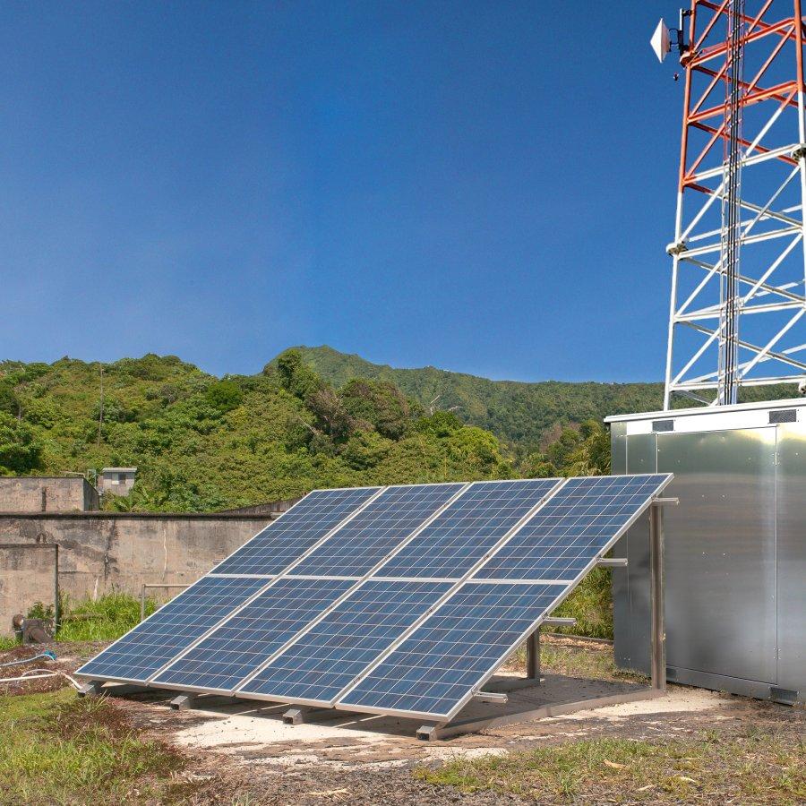 Solar panel next to antenna tower.