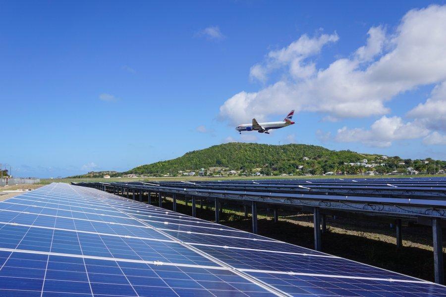 Airplane flying above the sun2live solar power plant at the V.C. Bird International Airport Antigua.