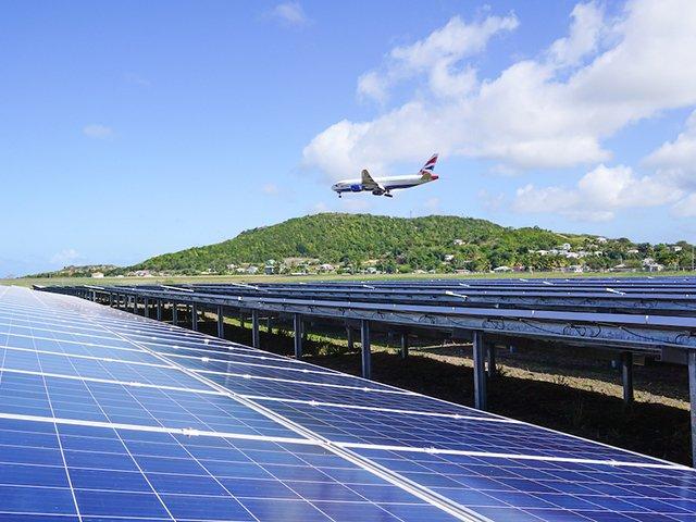 Airplane flying above the sun2live solar power plant at the V.C. Bird International Airport Antigua.