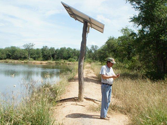 A Paraguayan rancher and the solar panel of its solar water pumping solution sun2flow.