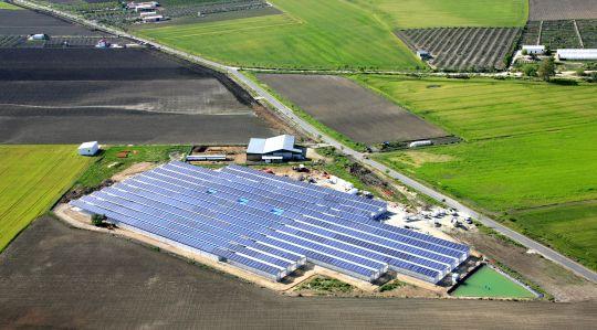 Greenhouse on a field with solar rooftop installation.