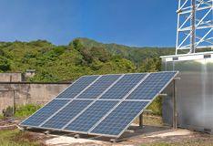 Solar panel next to antenna tower.